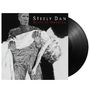 Text: "Steely Dan Alive in America". Eine mumienartige Kreatur hält eine bewusstlose, blonde Frau im Arm. Schallplatte sichtbar.