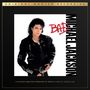 „Original Master Recording“ oben, „Michael Jackson“ rechts, „BAD“ in Rot. Person in schwarzer Lederjacke.