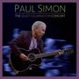 „PAUL SIMON: THE QUIET CELEBRATION CONCERT“. Ein Mann spielt Gitarre vor verschwommenem Hintergrund.