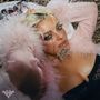Text: "Dirty Blonde". Eine Person mit blonden Haaren in einem Feder-Outfit liegt entspannt.