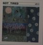 "NOT TIRED" und Namen von Musikern. Kunstcollage mit geometrischen Formen, weißen Bäumen und einem Hasen.