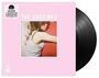 „THE VACCINES“ auf rosa Hintergrund, daneben Vinyl-Schallplatte. Bild zeigt Umarmung von Frau in weißem Top.