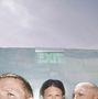 Leuchtreklame mit "EXIT" über teilweise verdeckten Köpfen von drei Personen vor einem wolkigen Himmel.