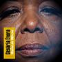 "Cesária Évora - Reina da Morna" steht links auf gelbem Hintergrund. Nahaufnahme eines Gesichts mit geschlossenen Lippen.