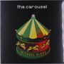 Text: "the carousel" oben, "MICHAEL ALDAG" unten. Illustration eines Karussells mit grünen und gelben Paneelen und Pferden.