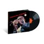 "Coltrane live at Birdland" in roter Schrift, unscharfe Aufnahme eines Jazzmusikers mit Saxophon, Vinyl daneben.