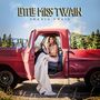 Text: „Little Miss Twain“, „Shania Twain“. Eine Frau in einem alten roten Truck vor einer Berglandschaft.