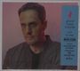 Ein Mann mit ernstem Blick, daneben ein blaues Banner mit "grand corps malade – voir la mer" und Infos zum neuen Album.