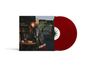 "DAY AND NIGHT", "CARLY RAE JEPSEN". Frau in dunklem Mantel an Tisch, rote Schallplatten daneben.