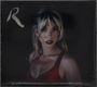 Der Text "R" in der linken oberen Ecke. Eine Frau mit blonden Haaren und rotem Top auf dunklem Hintergrund.