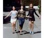 Drei Frauen gehen fröhlich eine Straße hinunter. Links steht "HAIM relationships ep". Alle wirken ausgelassen.