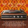 "The 70s - Classics: 1970-1974" steht vor retro Muster. Plattenspieler mit hölzerner Verkleidung unten, Künstlernamen darunter.