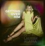 „GETTING OVER HIM“ und „LAUREN ALAINA“, Person in gelbem Kleid sitzt auf einem Sofa.