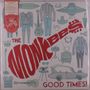 Der Text "THE MONKEES GOOD TIMES!" in Rot. Illustration von bunten Kleidungsstücken, Musikinstrumenten und Retro-Gegenständen.