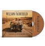 Text: "Wilson Fairchild: American Songbook. Country Classics and Gospel Favorites." Zwei Männer lehnen an einem Auto in Wüstenlandschaft.