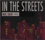 Texte: "IN THE STREETS", "NEIL GRAY", "CELLAR". Illustration: Bunte, schiefe Hochhäuser vor dunklem Hintergrund.