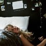 Der Text auf der Wand lautet "undividedyouare DC". Eine Frau mit blondem Haar liegt entspannt auf einem weißen Kissen.