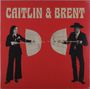 "Caitlin & Brent" in großen Buchstaben auf rotem Hintergrund. Zwei Personen halten offene Regenschirme.