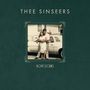 Text: THEE SINSEERS, LOVE STORIES. Ein Paar umarmt sich vor einem Auto.
