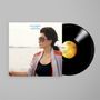 Text: "IT'S ALRIGHT, YOKO ONO". Eine Frau mit Sonnenbrille am Meer, sowie eine Schallplatte rechts daneben.