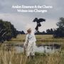„Avalon Emerson & the Charm, Written into Changes“. Eine Person in weißer Kleidung hält einen Greifvogel auf einer Wiese.