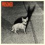Text "PRISONER" in Rot oben links. Illustration eines kleinen Hundes mit Schatten auf Asphalt.