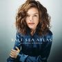 „SALT SEA ATLAS“, „KATHRINE WINDFELD“. Frau mit lockigem Haar und blauem Hemd schaut direkt nach vorne.
