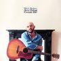 Oben steht "Max Subar Anything Could Be". Eine Person sitzt mit einer Gitarre vor einem Kamin.