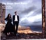 "The Deeps Have Music. Beth Taylor, Hamish Brown. Zwei Personen im Freien vor bewölktem Himmel, felsige Küste."