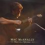 "MAC McANALLY - Once in a Lifetime." Ein Mann spielt sanft Gitarre in gedämpftem Licht, sein Gesicht teils beschattet.
