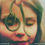 Texte: "SUPERHEAVEN", "OURS IS CHROME". Ein Kind mit geschlossenen Augen lächelt, hält eine kleine Schlange.