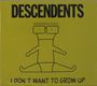 Text: "DESCENDENTS" und "I DON'T WANT TO GROW UP". Eine einfache Zeichnung einer dünnen Figur mit Brille.