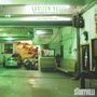 "Karsten Vogel. Late Night Ballads. Auto-Service Ort mit mehreren Fahrzeugen und Personen, die arbeiten oder warten."