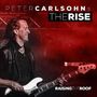 “PETER CARLSOHN's THE RISE, RAISING THE ROOF.” Ein Mann spielt E-Bass in einer Bühne mit roter Beleuchtung.