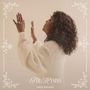 "The Hymns" und "CeCe Winans". Eine Frau in weißem Pullover erhebt ihre Hände, umgeben von floralen Ornamenten.