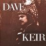 Text: "DAVE KEIR". Ein Mann mit Mütze schaut in die Ferne, umgeben von Bäumen und einer dunklen, stimmungsvollen Atmosphäre.