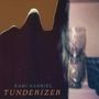 RAMI GABRIEL TUNDERIZER. Im Hintergrund verschwommene Skulptur und dunkler, geheimnisvoller Umriss im Vordergrund.