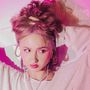 Der Text "like madonna" erscheint. Eine Frau hält ihr Haar, trägt Ohrringe und eine Kette, in pink beleuchtet.