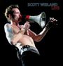 Text: "SCOTT WEILAND LIVE". Ein Mann mit freiem Oberkörper spricht in ein Megafon auf der Bühne.