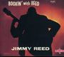 "ROCKIN' with REED" und "JIMMY REED" in Großbuchstaben. Silhouette eines Gitarristen vor rotem Hintergrund.