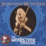 "Johnny Winter" und "The Woodstock Experience". Ein Musiker spielt leidenschaftlich Gitarre, umrahmt von blauen Verzierungen.