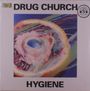 „DRUG CHURCH“ und „HYGIENE“. Abstraktes Kunstwerk in der Mitte mit bunten, wirbelnden Formen und einem blauen Zentrum.