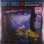 „GOV'T MULE“, „BRING ON THE MUSIC“, „LIVE AT THE CAPITOL THEATRE: VOL. 1“. Bühne mit buntem Licht und Musikern.