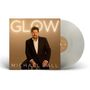 "Glow" und "Michael Ball" auf einem Albumcover. Ein Mann in Anzug sitzt lächelnd. Eine Schallplatte daneben.