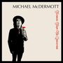 "MICHAEL McDERMOTT" oben, "Flowers From The Graveyard" rechts in Rot. Mann mit Hut hält rote Blume.