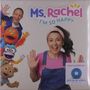 „Ms. Rachel, I'M SO HAPPY“ und „Limited Edition ECO BLUE VINYL“. Eine lächelnde Frau und bunte Puppen heben die Hände.