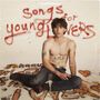 „Songs for young lovers“ steht an der Wand. Ein junger Mann sitzt oben ohne auf dem Boden, umgeben von Tattoos.