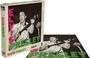 "Elvis Presley" steht in großen Buchstaben auf einer Puzzlebox. Ein Mann spielt Gitarre und singt leidenschaftlich.
