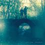 Joan Shelley, Over and Even. Zwei Personen stehen auf einer Brücke im Wald, umgeben von Bäumen.