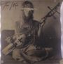 Oben steht „The Witch“. Eine Frau sitzt und hält ein Streichinstrument. Das Bild ist in Sepia gehalten.